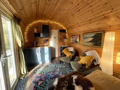 a living room with a couch and a kitchen at Raiders Rest - near pub and shop in Palnackie