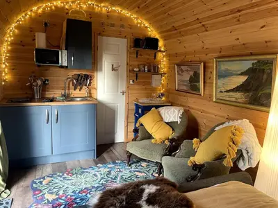 a room with two chairs and a kitchen in a cabin at Raiders Rest - near pub and shop in Palnackie