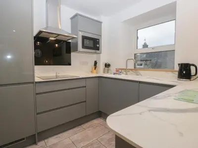 a kitchen with white counters and a sink and a window at 6 Hallin Fell in Watermillock