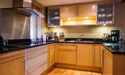 a kitchen with wooden cabinets and black counter tops at Watendlath in Applethwaite