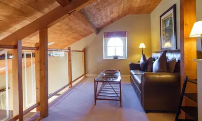a living room with a leather couch and a table at Underscar - Hindscarth in Applethwaite