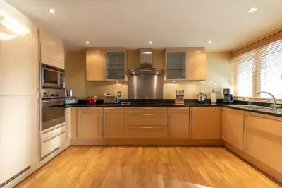 a kitchen with wooden cabinets and stainless steel appliances at Underscar - Ashness in Applethwaite