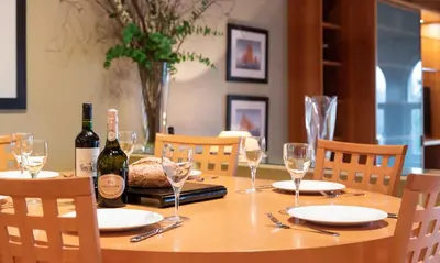 a wooden table with two bottles of wine and glasses at Brackenburn in Applethwaite
