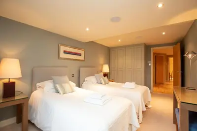 a bedroom with two beds with white sheets at Castlerigg in Applethwaite