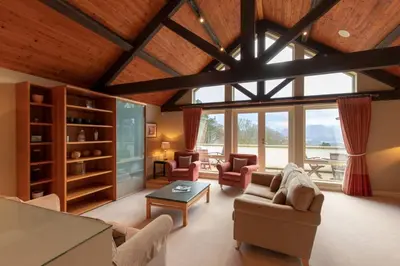 a living room with furniture and a large window at Castlerigg in Applethwaite