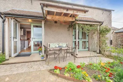 a patio with a table and chairs in front of a house at 3 Bed in Kirkbampton oc-l32005 in Burgh by Sands