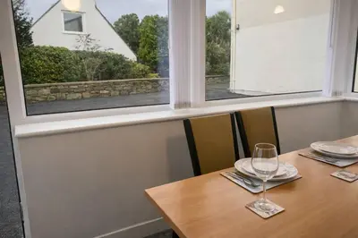 a table with a glass of wine on it with a window at The Croft in Ramsey