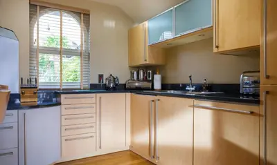 a kitchen with wooden cabinets and black counter tops at Underscar - High Spy in Applethwaite