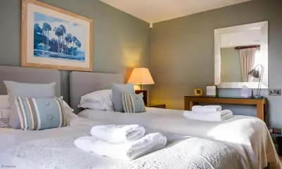 two beds in a hotel room with towels on them at Underscar - High Spy in Applethwaite