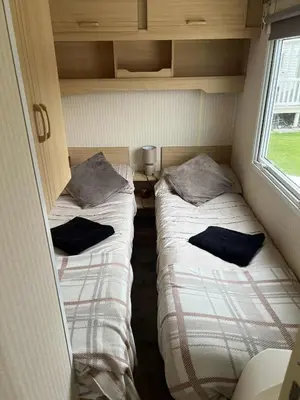 two beds in a small room with a window at Mags Home from Home at Southerness in Mainsriddle