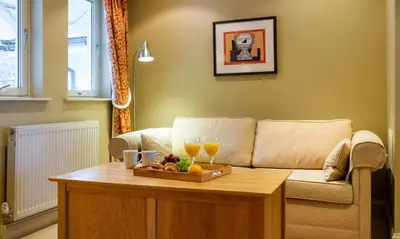 a living room with a couch and a table with drinks at Underscar - Newlands in Keswick