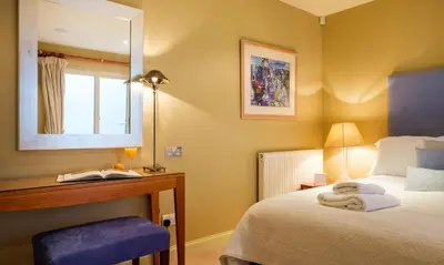a bedroom with a bed and a desk and a mirror at Underscar - Newlands in Keswick