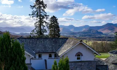a house with a roof with mountains in the background at Underscar - Newlands in Keswick
