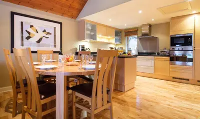 a kitchen with a wooden table and chairs in a kitchen at Underscar - Newlands in Keswick