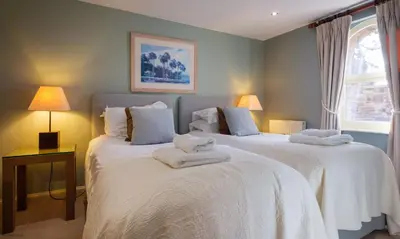 a bedroom with two beds with towels on them at Underscar - Seatoller in Keswick