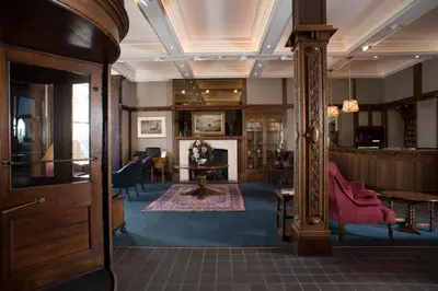 a living room with a fireplace and a mirror at Regency Hotel in Douglas