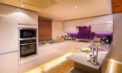 a kitchen with white appliances and purple walls at Underscar - Whinlatter in Keswick