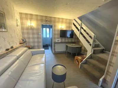 a living room with a white couch and a staircase at Cosy Cottage in Moffat Town Centre - Pass the Keys in Moffat