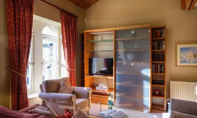 a living room with a book shelf and a tv at Underscar - Great Gable in Keswick