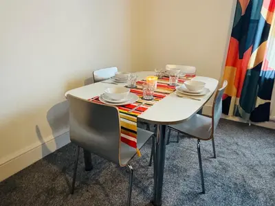 a dining room table with chairs and a tablecloth on it at Vulcan Apartment - 3 Bedrooms - Sleeps 6 in Workington