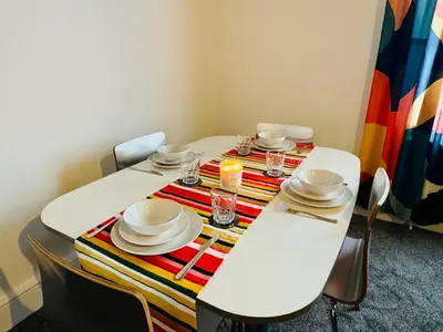 a white table with plates and glasses on it at Vulcan Apartment - 3 Bedrooms - Sleeps 6 in Workington