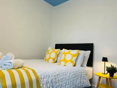 a bedroom with a bed with yellow and white pillows at Vulcan Apartment - 3 Bedrooms - Sleeps 6 in Workington