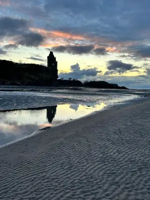 a reflection of a building in the water on a beach at The Beach View - Greenan in Ayr