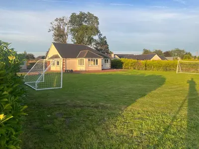 a yard with a soccer net in the grass at Rural luxury bungalow in Terreglestown