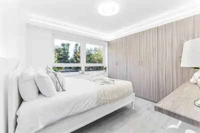 a white bedroom with a large bed and a window at Luxury 1 Bed near Hyde Park and Marble Arch in Moffat