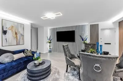 a living room with a blue couch and a tv at Luxury 1 Bed near Hyde Park and Marble Arch in Moffat