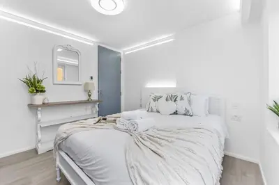 a white bedroom with a white bed and a mirror at Luxury 1 Bed near Hyde Park and Marble Arch in Moffat