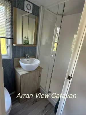 a bathroom with a white sink and a shower at Arran View Caravan in Ayr