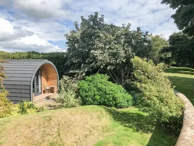 a small cabin in the middle of a garden at The Eden Hideaway - Uk1554 in Rockcliffe