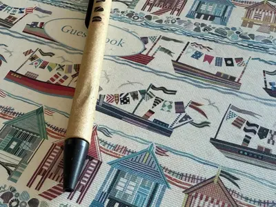 a pen sitting on top of a sheet with a boat at Cliff Cottage Beautifully appointed apartment with world class view in Peel