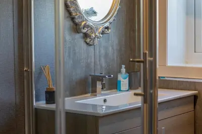 a bathroom with a sink and a mirror at The Bridge- 3 Bedrooms in Coatbridge with Driveway in Moffat