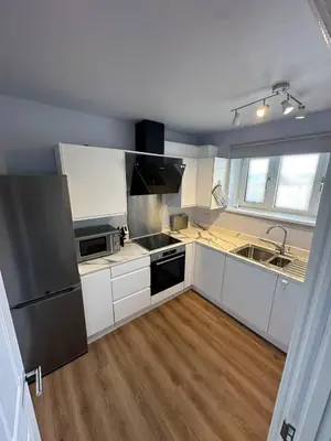 a kitchen with white cabinets and a stainless steel refrigerator at 3x Large Double bedroom, Central London flat in Moffat