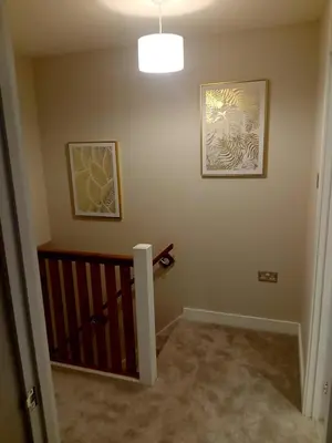 a room with a crib and two pictures on the wall at Martindale Close - 3 Bedrooms - Sleeps 5 in Whitehaven