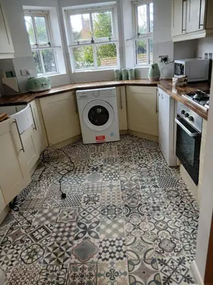 a kitchen with a washing machine on a tile floor at Fabulous 4 Bed House in Leiston in Moffat