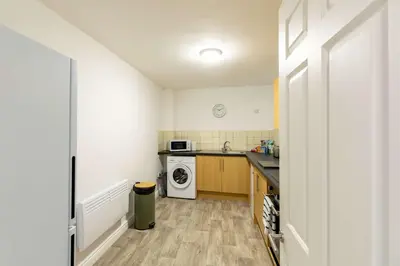 a small kitchen with a washer and dryer at 1 Bed Whitehaven Harbour-side Flat with Sea Views in Whitehaven