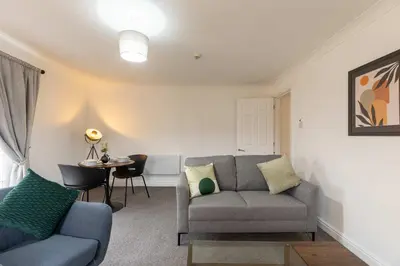 a living room with a couch and a table at Bright 1 Bed Harbour-side Apartment w Sea Views in Whitehaven