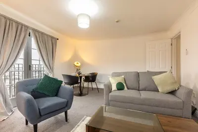a living room with a couch and a chair and a table at Bright 1 Bed Harbour-side Apartment w Sea Views in Whitehaven
