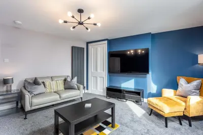 a living room with a couch and a table at No8 Peebles Retreat - Donnini Apartments in Ayr