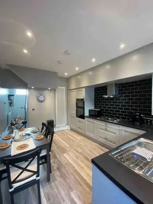 a kitchen and living room with a table and chairs at 26 Challoner Street, Cockermouth, CA13 9QS in Cockermouth