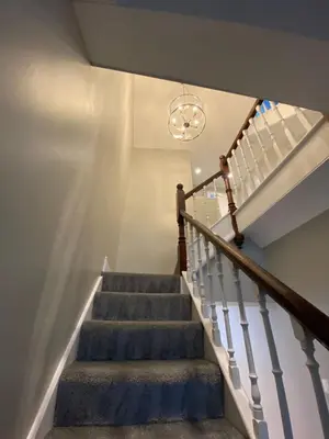 a staircase with a chandelier in a house at 26 Challoner Street, Cockermouth, CA13 9QS in Cockermouth