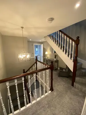 a staircase in a home with a chandelier at 26 Challoner Street, Cockermouth, CA13 9QS in Cockermouth