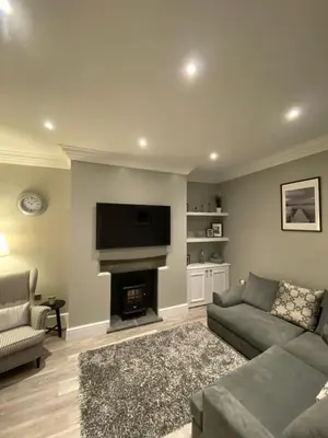 a living room with a couch and a fireplace at 26 Challoner Street, Cockermouth, CA13 9QS in Cockermouth