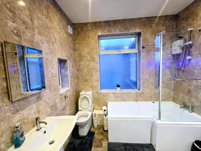 a bathroom with a tub and a toilet and a sink at Acadia House Blyth in Moffat