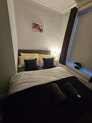 a bedroom with a large bed with a window at Acadia House Blyth in Moffat