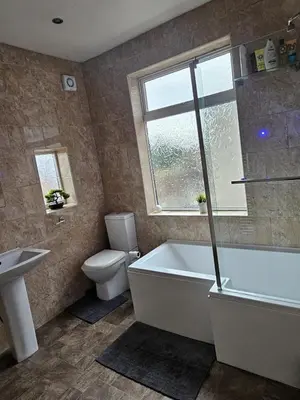 a bathroom with a tub and a toilet and a sink at Acadia House Blyth in Moffat