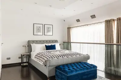 a bed with a blue ottoman in a bedroom at New! Modern Wapping 1BR Flat near Tower Bridge in Moffat